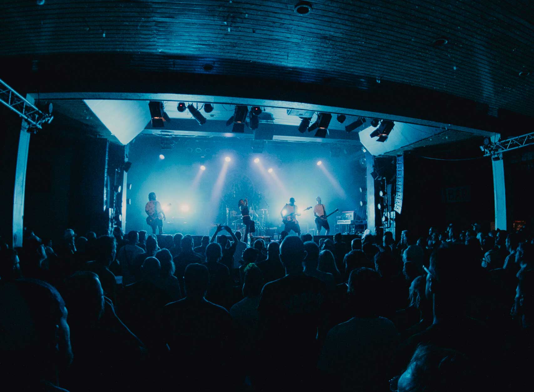 Melonball playing in front of a big crowd inside a concert hall.